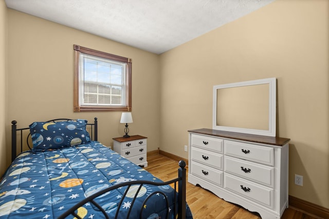 bedroom with light wood-style flooring and baseboards