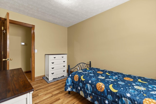 bedroom featuring light wood-style floors and a textured ceiling