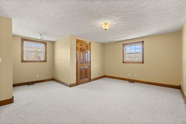 spare room with carpet floors, visible vents, plenty of natural light, and baseboards