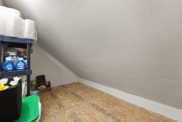 additional living space featuring vaulted ceiling and a textured ceiling