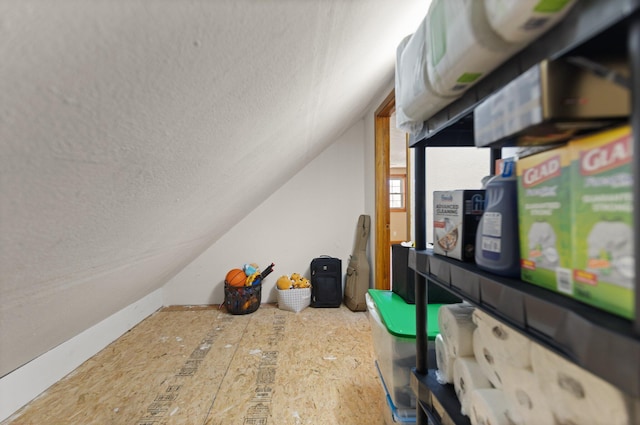 bonus room featuring lofted ceiling and a textured ceiling