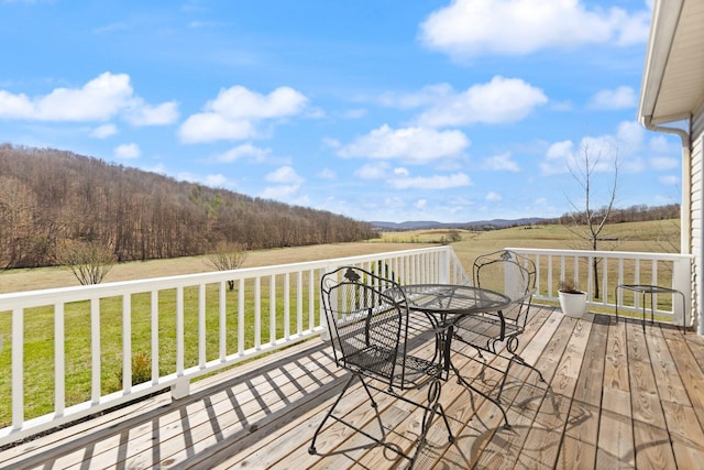 deck featuring a yard, outdoor dining space, and a rural view