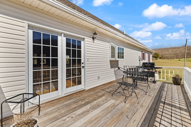 deck with outdoor dining area and area for grilling