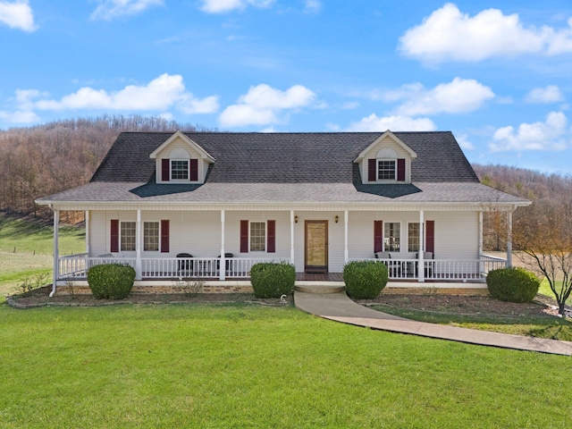 farmhouse featuring roof with shingles, a porch, and a front yard