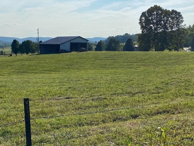 view of yard with a pole building, an outbuilding, and a rural view