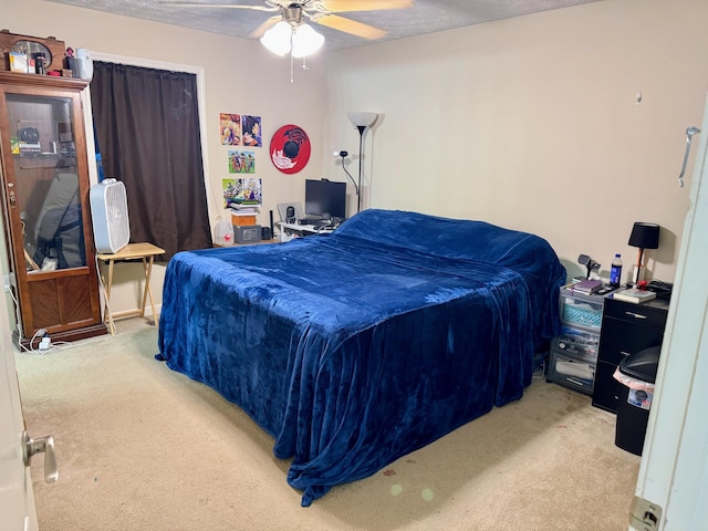 carpeted bedroom with ceiling fan and a textured ceiling