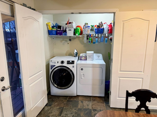 clothes washing area with laundry area, stone finish floor, and separate washer and dryer