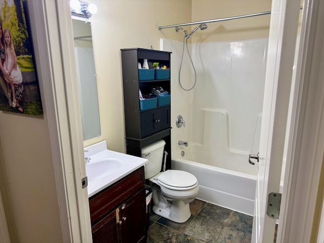 full bathroom with stone finish floor, vanity, toilet, and shower / bathtub combination