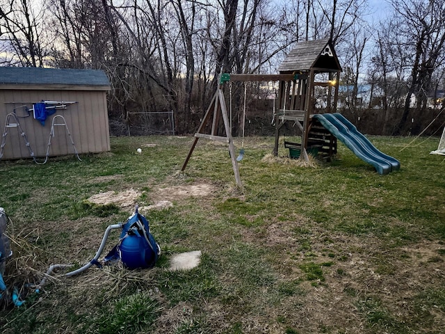 view of play area with an outbuilding, a lawn, and a storage shed