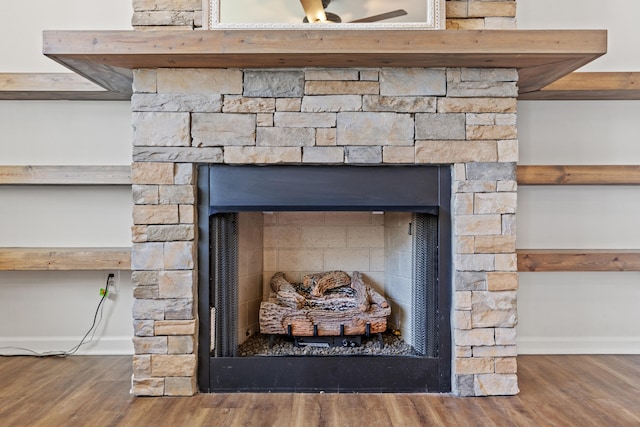 room details with a fireplace, wood finished floors, and baseboards