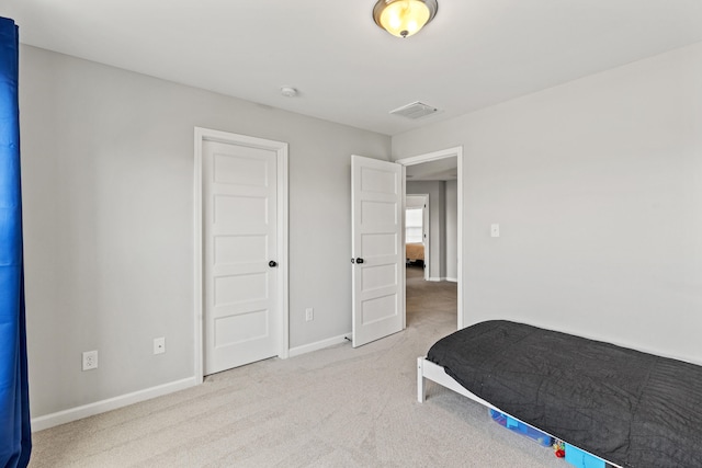 carpeted bedroom with visible vents and baseboards