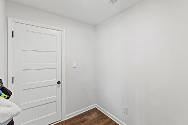 empty room featuring dark wood-style flooring and baseboards