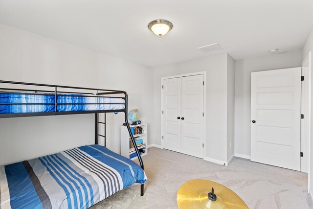 carpeted bedroom featuring a closet and baseboards