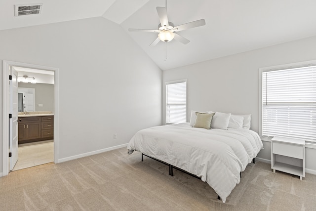 bedroom featuring baseboards, visible vents, connected bathroom, light colored carpet, and high vaulted ceiling