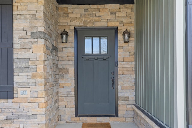 doorway to property with stone siding and brick siding