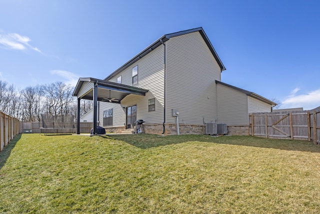 view of home's exterior with a fenced backyard, ceiling fan, central AC, and a yard