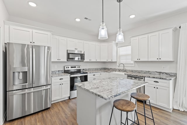 kitchen featuring stainless steel appliances, white cabinets, visible vents, and a sink