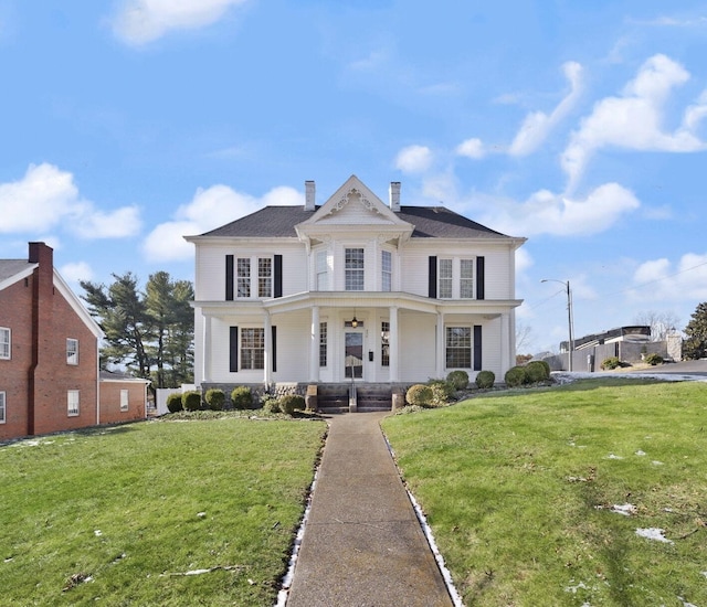 view of front of house featuring a front lawn, a chimney, and a porch