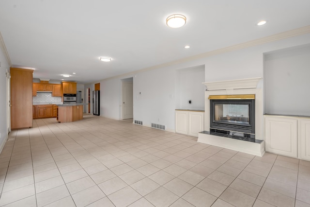 unfurnished living room with light tile patterned flooring, a fireplace, visible vents, and ornamental molding