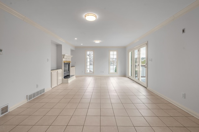 unfurnished living room featuring visible vents, ornamental molding, a high end fireplace, light tile patterned flooring, and baseboards