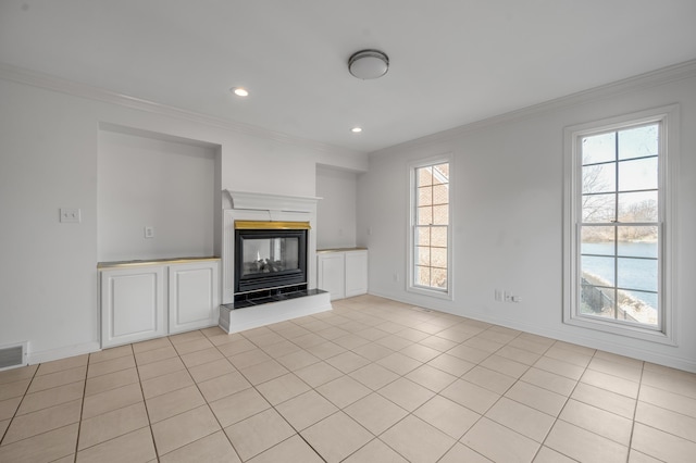 unfurnished living room with recessed lighting, baseboards, crown molding, and a tiled fireplace