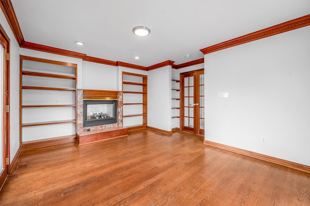 unfurnished living room with baseboards, wood finished floors, crown molding, french doors, and a multi sided fireplace