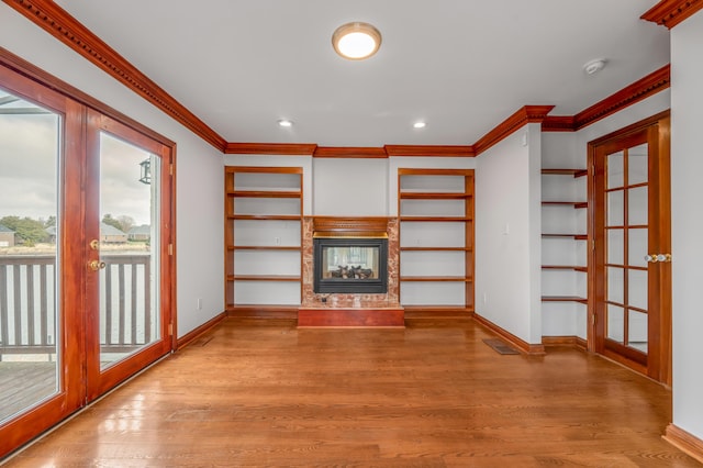 unfurnished living room featuring ornamental molding, baseboards, a multi sided fireplace, and wood finished floors