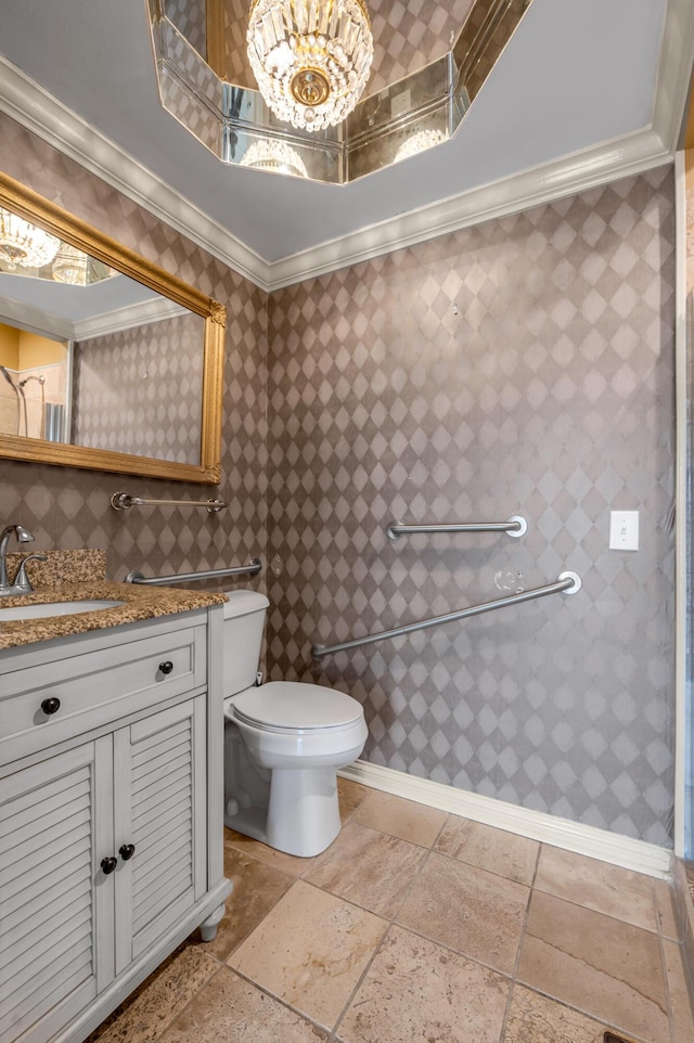 bathroom featuring toilet, stone tile floors, ornamental molding, and vanity