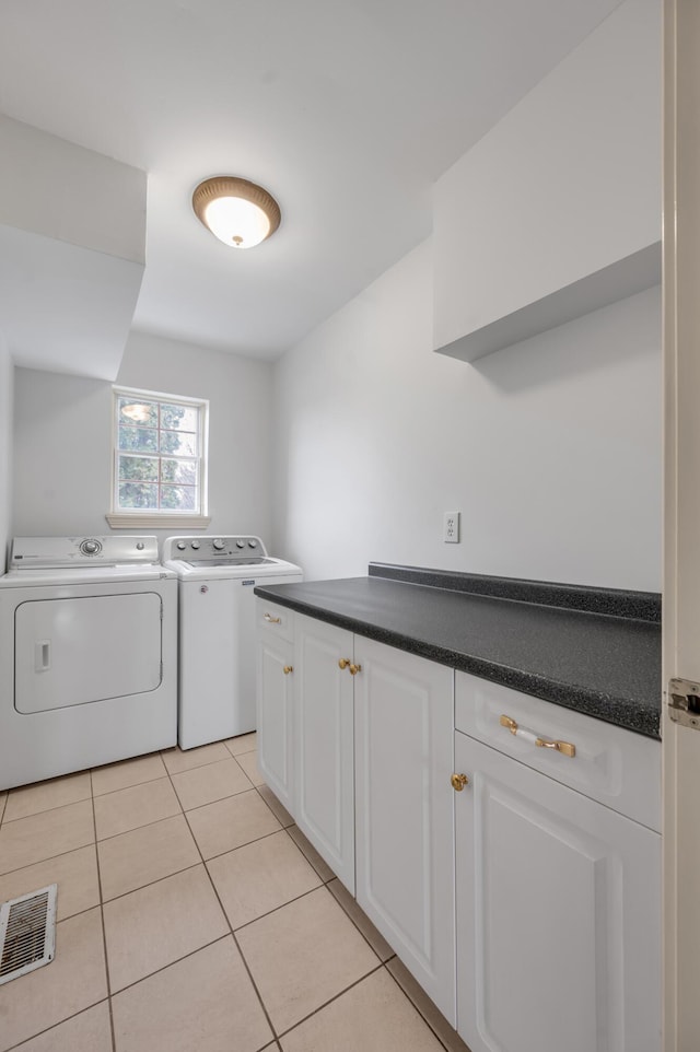 laundry room featuring light tile patterned flooring, washing machine and dryer, and visible vents