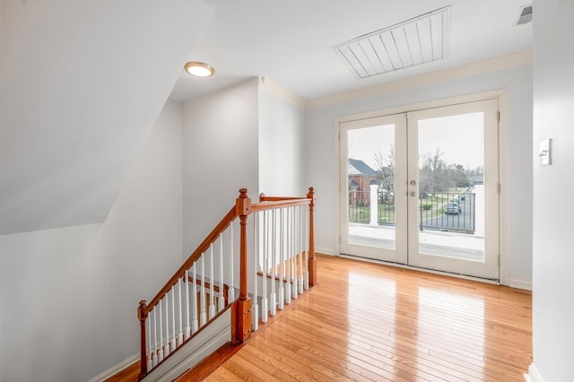 interior space with wood-type flooring, visible vents, baseboards, and french doors