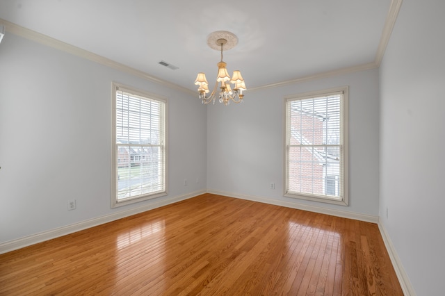 spare room with baseboards, visible vents, crown molding, and light wood finished floors