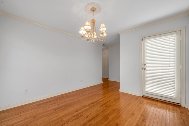 empty room with baseboards, a chandelier, light wood-style flooring, and crown molding