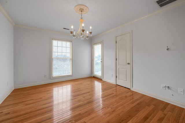 unfurnished room featuring light wood finished floors, visible vents, and crown molding