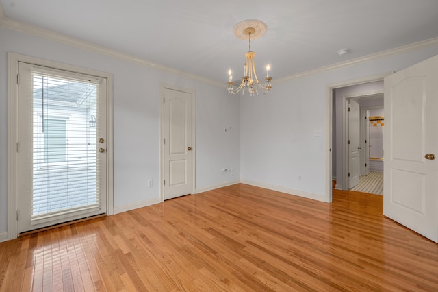 empty room featuring light wood-type flooring, crown molding, and baseboards