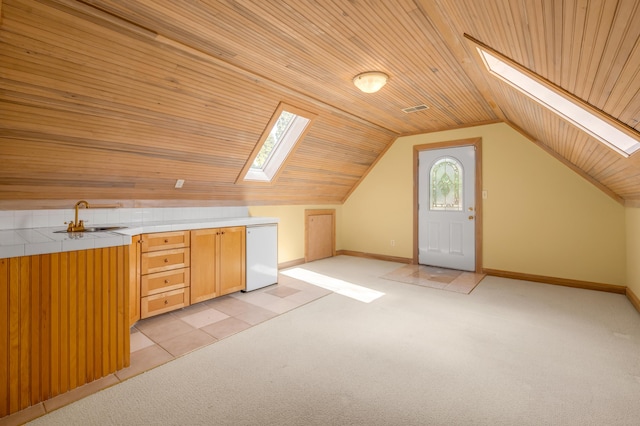 bonus room featuring light carpet, lofted ceiling with skylight, a sink, and wood ceiling