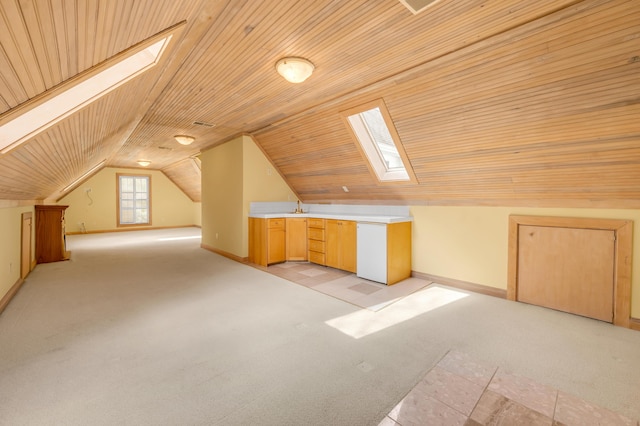 bonus room featuring wood ceiling, vaulted ceiling with skylight, baseboards, and light colored carpet