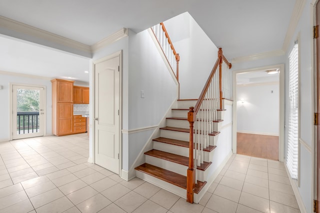 stairs featuring tile patterned flooring, crown molding, and baseboards