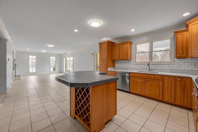 kitchen featuring tasteful backsplash, a sink, stainless steel dishwasher, and light tile patterned floors