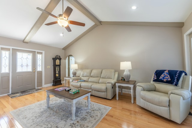 living area with vaulted ceiling with beams, arched walkways, light wood-style flooring, a ceiling fan, and baseboards