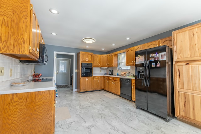 kitchen with decorative backsplash, marble finish floor, light countertops, black appliances, and a sink