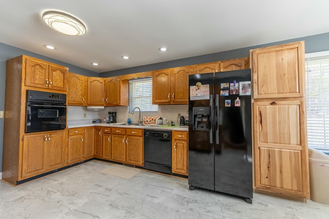 kitchen featuring a sink, marble finish floor, light countertops, black appliances, and tasteful backsplash