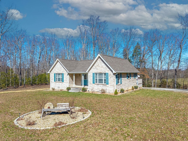 ranch-style house featuring brick siding, roof with shingles, and a front yard