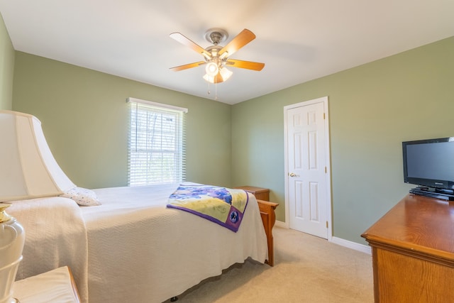 bedroom with a ceiling fan, light colored carpet, and baseboards