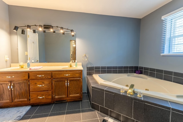 full bathroom with double vanity, a tub with jets, a sink, and tile patterned floors