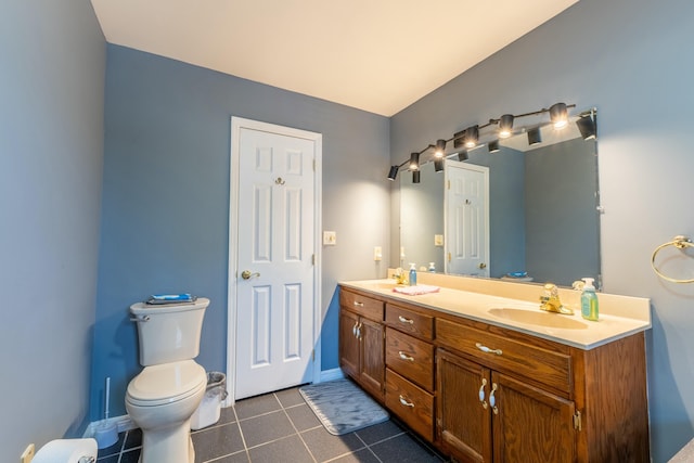 full bath featuring double vanity, baseboards, toilet, tile patterned flooring, and a sink