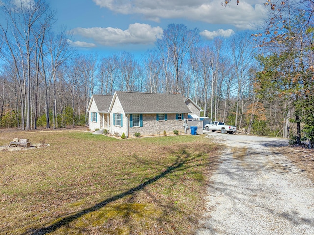 view of front of property with a front lawn and gravel driveway