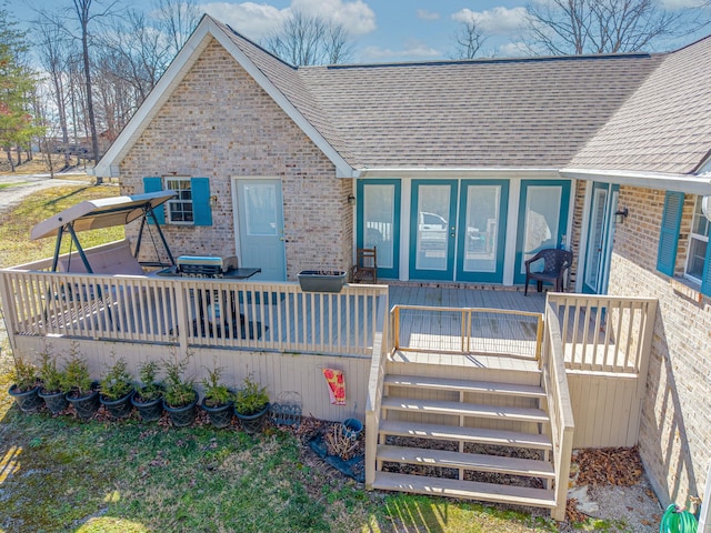 view of front of home with a shingled roof and brick siding