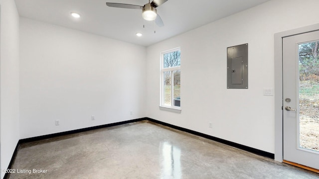 spare room featuring recessed lighting, a ceiling fan, electric panel, concrete floors, and baseboards