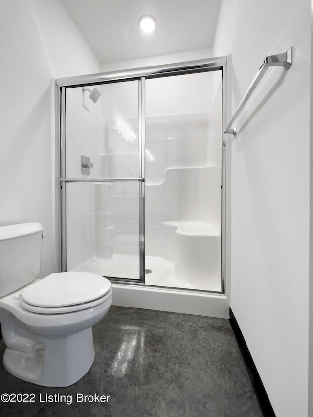 bathroom featuring concrete floors, a stall shower, and toilet