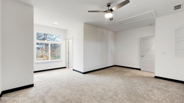 carpeted spare room featuring attic access, visible vents, and baseboards